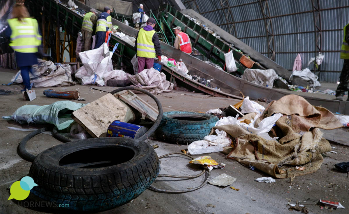 В момент отгрузки мусора на конвейер рабочие вытаскивают все 