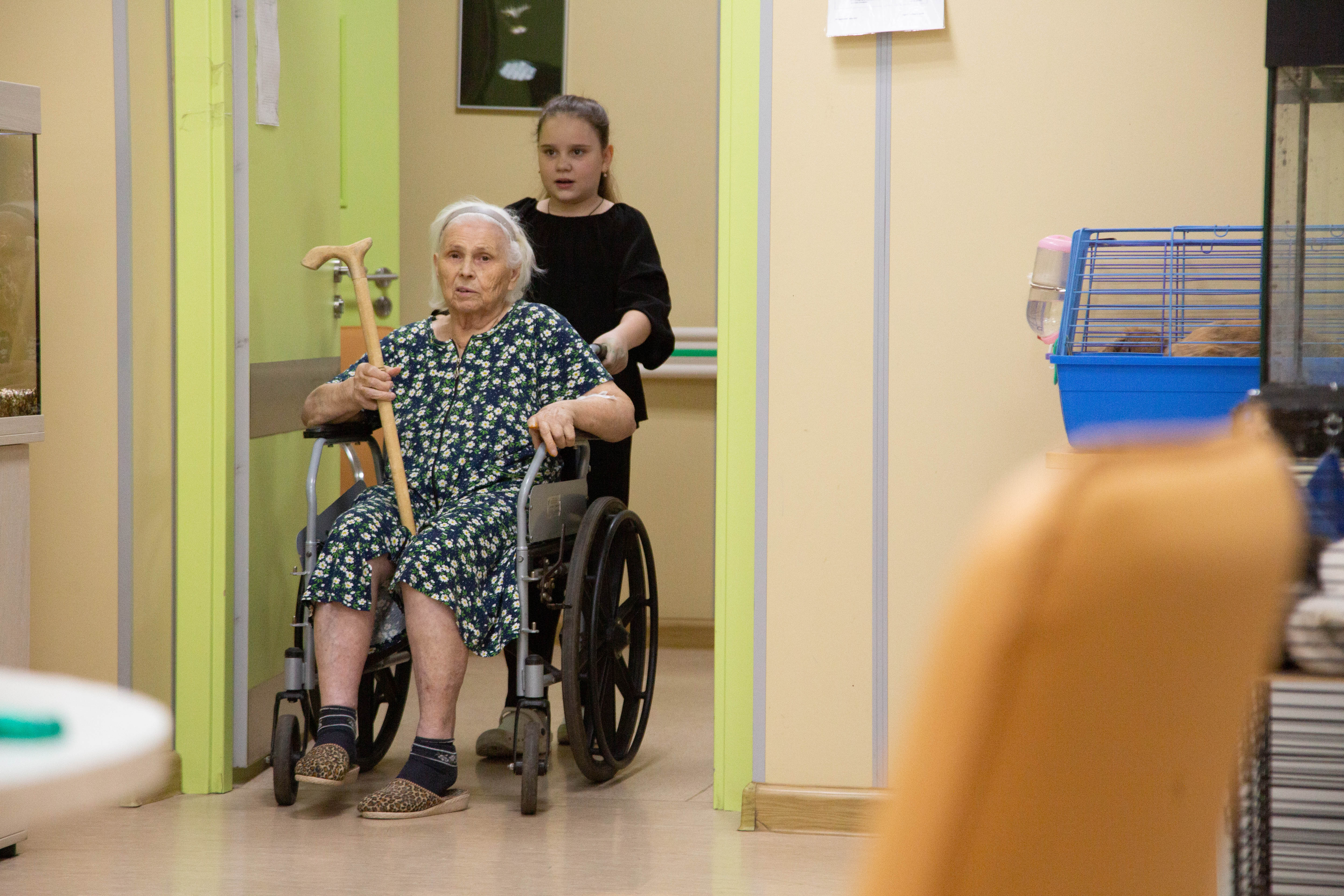 Валя помогает пациентам добраться из палаты до комнаты, где проходят занятия